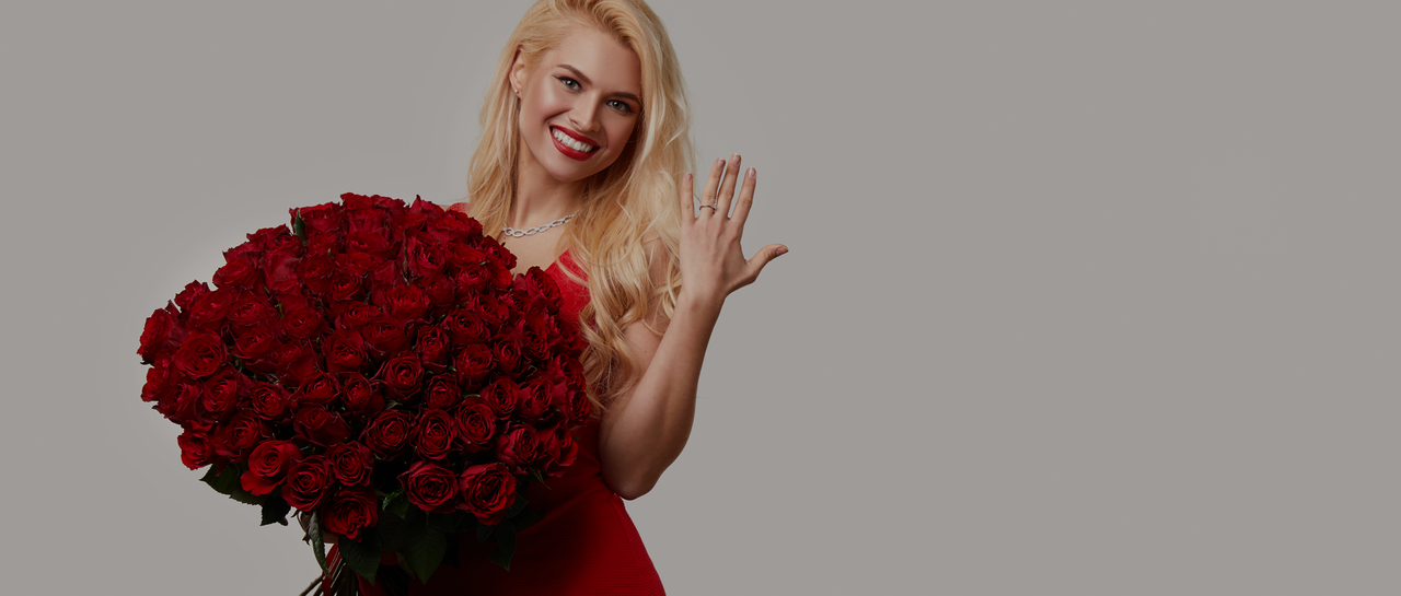 Woman in red holding a bouquet of luxurious red roses from Ecuador